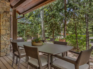 Enjoy outdoor dining in this beautiful space! This property features a covered patio with a dining table and chairs, perfect for entertaining or relaxing.