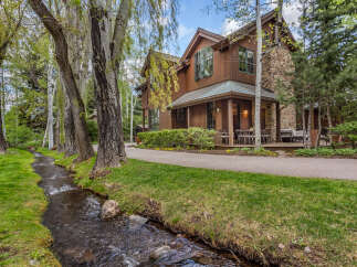 Nestled amidst lush greenery and a serene stream, this stunning property offers a tranquil escape.