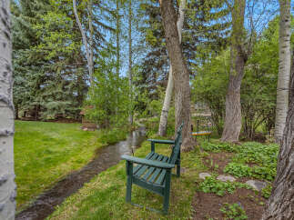 Escape to your own private oasis with this stunning property! Enjoy the tranquility of a serene stream, lush greenery, and mature trees.