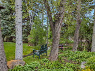 Discover the tranquility of this stunning property, featuring lush greenery and mature trees.