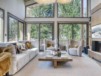 Experience luxury living in this stunning property, featuring a spacious living room with floor-to-ceiling windows that offer breathtaking views of the surrounding nature.