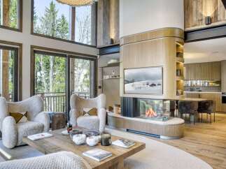 Experience luxury living in this stunning property, featuring a cozy fireplace and inviting seating area.