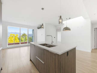 Experience modern living in this stunning kitchen with a sleek island and contemporary pendant lighting.