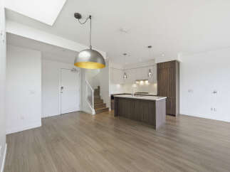 Step into modern luxury with this stunning property, featuring a sleek kitchen island and elegant hardwood floors.