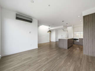 This stunning modern apartment boasts a spacious open-concept living area with beautiful hardwood floors.