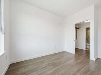 This bright and airy room features a modern design with clean white walls and beautiful wood-look flooring.