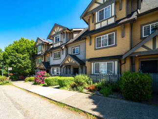 Discover this stunning townhome featuring a charming exterior with a mix of colors and architectural details.