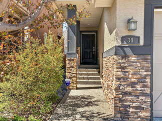Welcome to this stunning property! This home features a beautiful stone facade and a welcoming front entrance.