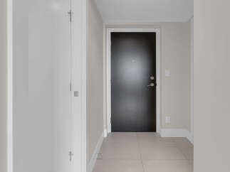 This stunning property features a modern design with a sleek black door and neutral-toned walls.