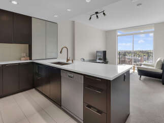 This modern kitchen boasts sleek dark cabinetry and a bright white countertop, creating a stylish and functional space.