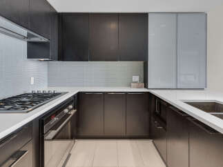 This modern kitchen boasts sleek, dark wood cabinetry and pristine white countertops, creating a sophisticated and functional space.