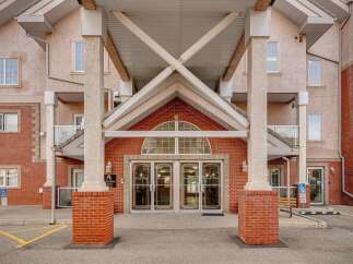 Discover the charm of this stunning property, featuring a welcoming entrance with elegant glass doors and a classic brick facade.