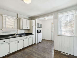This charming kitchen offers a bright and inviting space with its white cabinetry and ample counter space.
