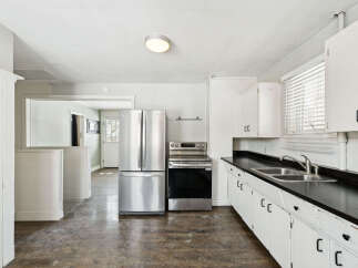 Step into this charming kitchen, featuring a stainless steel refrigerator and a modern range.