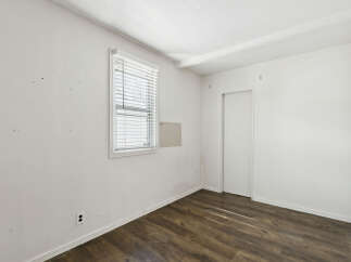 This inviting room features a bright, airy atmosphere with its pristine white walls and ample natural light.