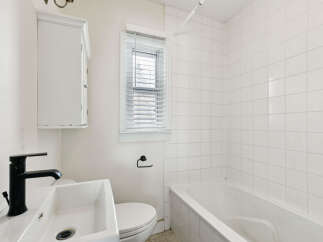 This bright and airy bathroom features a classic design with white tiles and a clean aesthetic.