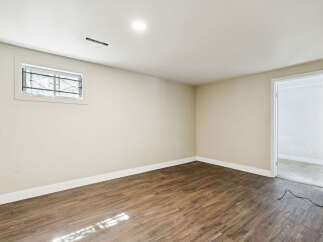 Discover the potential of this versatile space! This room features beautiful wood-look flooring, creating a warm and inviting atmosphere.
