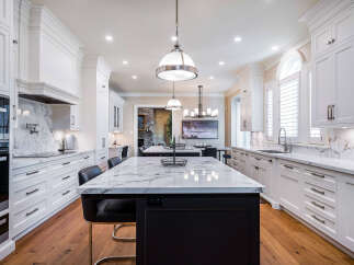 This stunning kitchen boasts a luxurious marble countertop and sleek white cabinetry, creating a bright and inviting space.