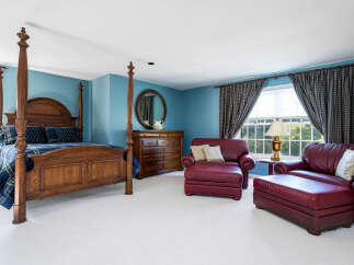 Step into luxury with this stunning bedroom featuring a grand four-poster bed and elegant seating area.