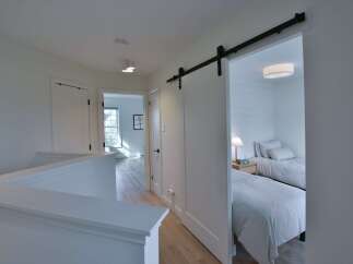 Discover the charm of this beautifully designed home! Featuring a bright and airy hallway leading to a cozy bedroom with two beds.