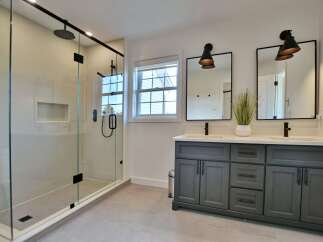 Step into luxury with this stunning bathroom featuring a modern glass shower and sleek black fixtures.