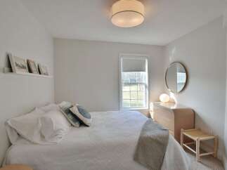 This serene bedroom offers a tranquil retreat with its minimalist design and neutral color palette.