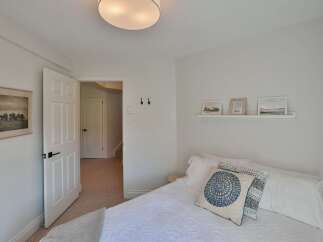 This inviting bedroom offers a serene retreat with its neutral color palette and ample natural light.