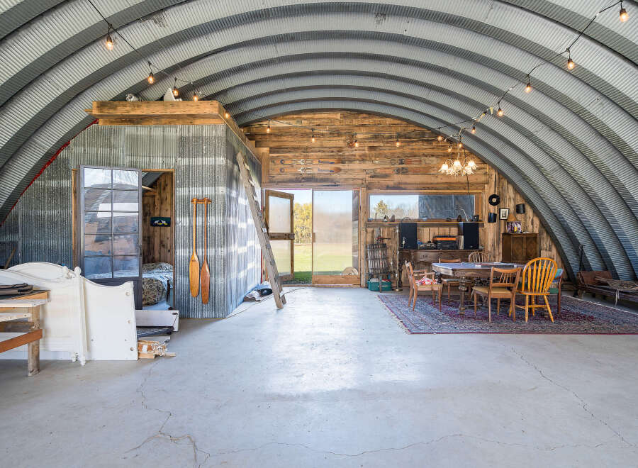 Discover this unique Quonset hut home, offering an expansive open-concept living space with rustic charm.