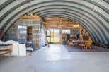 Discover this unique Quonset hut home, offering an expansive open-concept living space with rustic charm.
