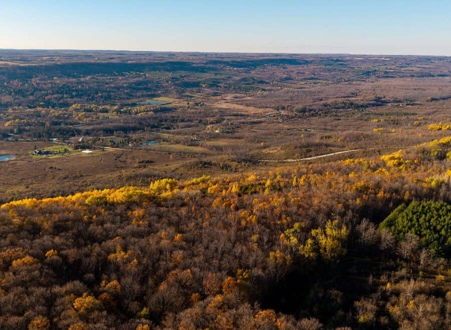 Experience the beauty of autumn from this elevated vantage point, showcasing rolling hills adorned with vibrant fall foliage.