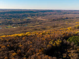 Experience the beauty of autumn from this elevated vantage point, showcasing rolling hills adorned with vibrant fall foliage.