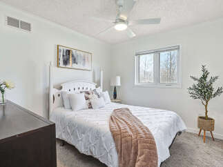 This bright and airy bedroom offers a serene retreat with its pristine white walls and ample natural light.