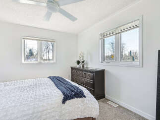 This bright and airy bedroom offers a serene retreat with its crisp white walls and ample natural light.