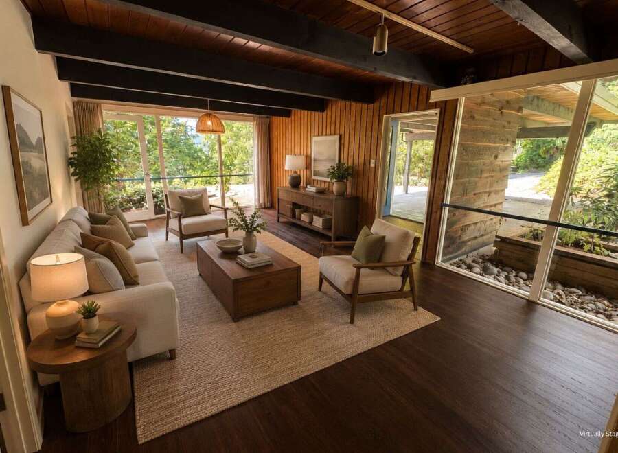Experience mid-century modern living in this stunning home featuring a wood-paneled living room with a beamed ceiling and large windows that bring the outdoors in.