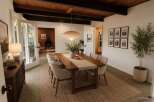 Experience elegant dining in this beautifully staged room, featuring a warm wood dining table set on a natural fiber rug.