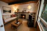 Cozy living room featuring a natural wood ceiling and a stone fireplace, perfect for relaxing evenings.