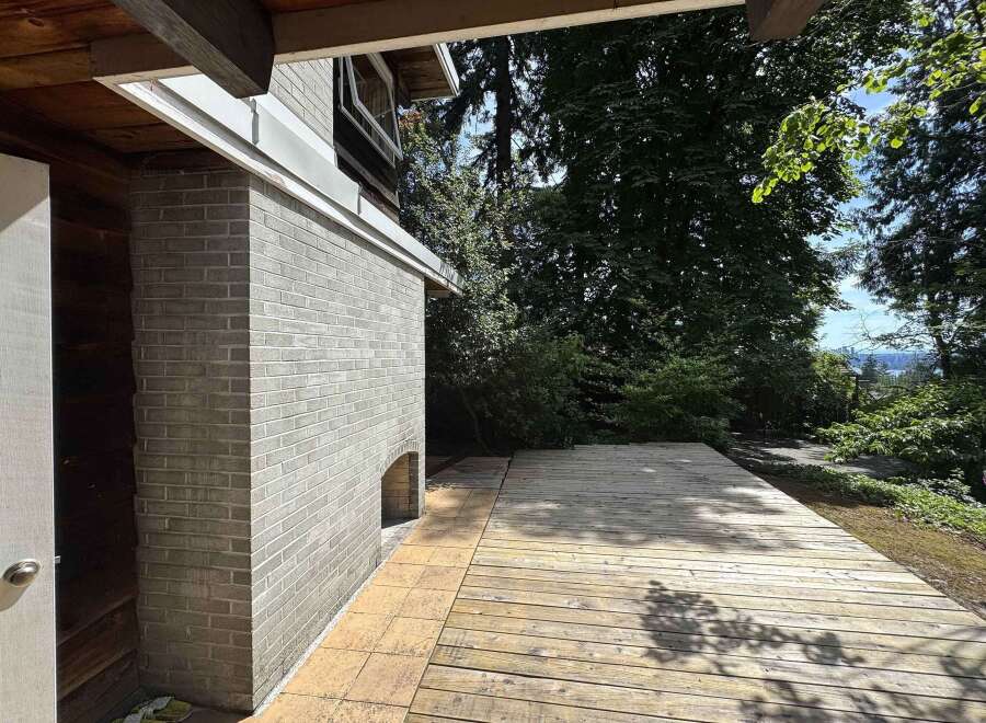 Discover this charming property featuring a rustic wooden deck perfect for outdoor entertaining, complemented by a classic brick exterior.