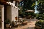 Experience outdoor living at its finest with this beautifully appointed deck, featuring a cozy brick fireplace and comfortable seating areas perfect for relaxation.