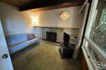 Cozy living room featuring a comfortable futon, a stone fireplace, and built-in shelving.