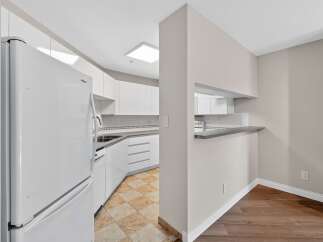 This stunning kitchen boasts modern white cabinetry, offering ample storage and a sleek aesthetic.