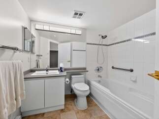 Step into this bright and airy bathroom, featuring a modern vanity and a convenient toilet.