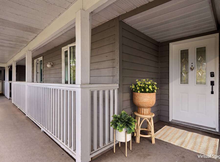 Welcome guests to this charming home with a covered front porch, perfect for enjoying your morning coffee.