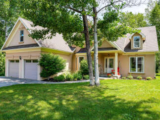 This stunning property boasts a beautiful exterior with a well-manicured lawn and lush landscaping.
