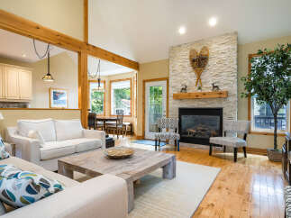 This stunning living room boasts a cozy fireplace with a stone facade, perfect for chilly evenings.