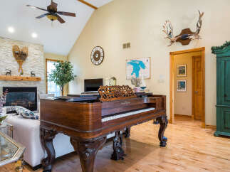 This stunning property boasts a spacious living area with a grand piano, perfect for entertaining or relaxing.