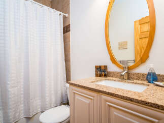 This bathroom features a stylish vanity with a granite countertop, offering ample space and a touch of luxury.