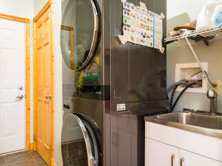 This laundry room features a modern stacked washer and dryer, maximizing space and efficiency.