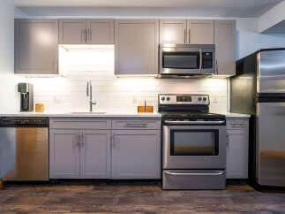 This modern kitchen boasts sleek, gray cabinetry and stainless steel appliances, creating a stylish and functional space.