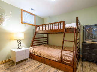 This cozy bedroom features a charming bunk bed, perfect for accommodating guests or creating a fun space for kids.