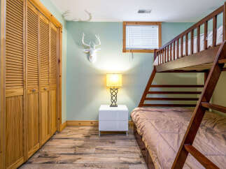 This cozy bedroom features a charming bunk bed, perfect for accommodating guests or family members.